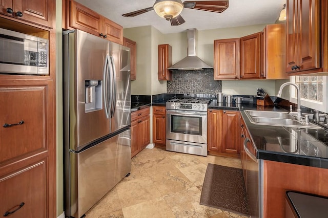 kitchen with appliances with stainless steel finishes, backsplash, wall chimney exhaust hood, ceiling fan, and sink