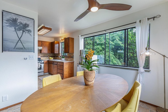 dining area featuring ceiling fan, sink, and light tile patterned floors