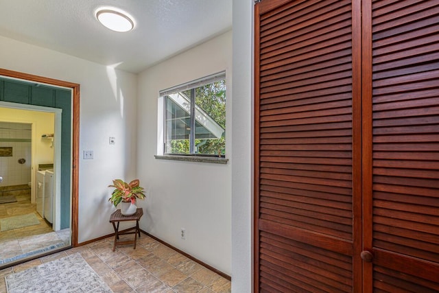 hall featuring a textured ceiling and washing machine and dryer