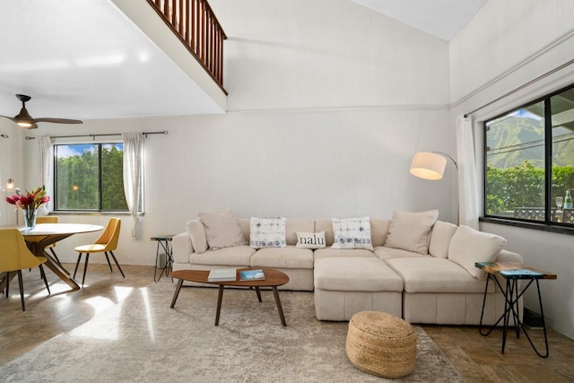 living room with ceiling fan and a high ceiling