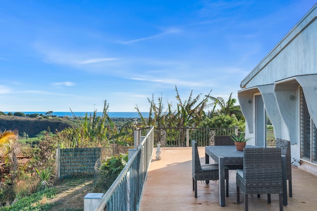 view of patio with a balcony and a water view