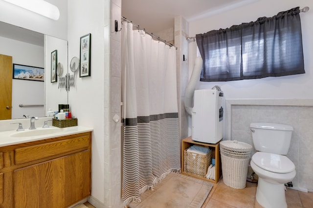 bathroom with tile patterned flooring, toilet, vanity, tile walls, and a shower with shower curtain