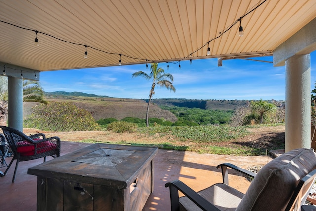 view of patio / terrace with a fire pit and a rural view