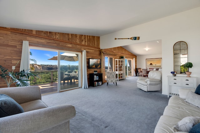 living room featuring carpet, lofted ceiling, and wood walls