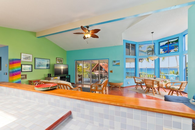 interior space with lofted ceiling with beams and ceiling fan