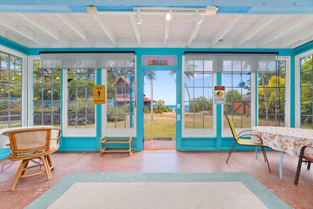 sunroom / solarium featuring beam ceiling