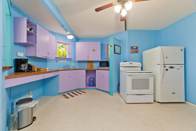 kitchen with blue cabinetry, wood counters, white appliances, and a textured ceiling