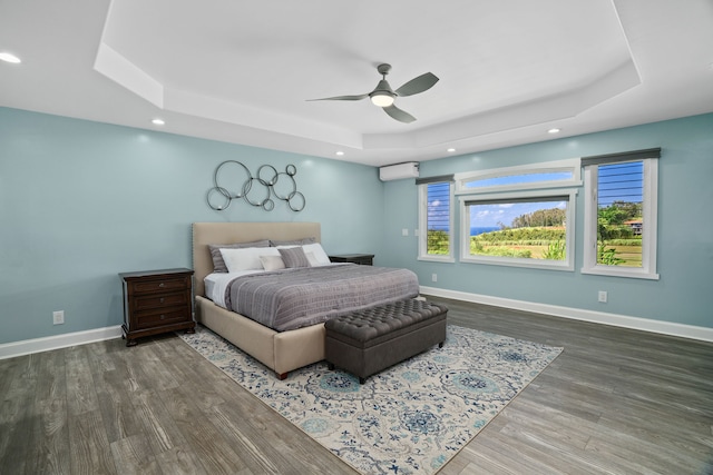 bedroom featuring a tray ceiling, ceiling fan, and hardwood / wood-style flooring