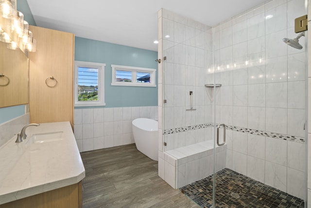 bathroom with plus walk in shower, vanity, and wood-type flooring