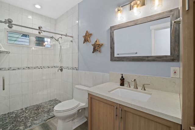 bathroom with walk in shower, vanity, and toilet