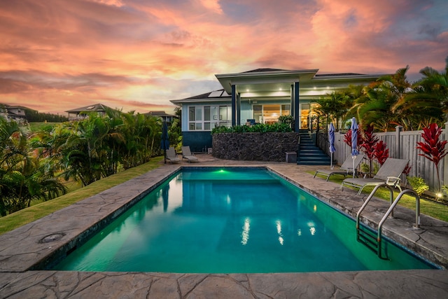 pool at dusk with a patio