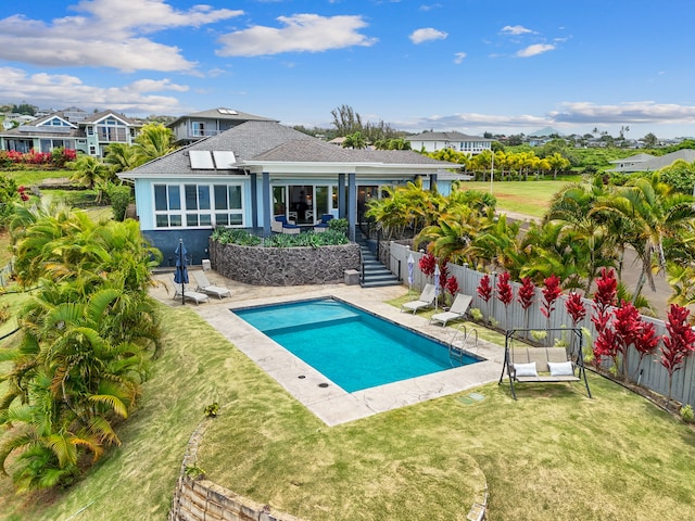 view of pool with a patio area and a yard