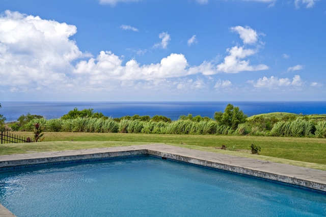 view of pool with a yard and a water view