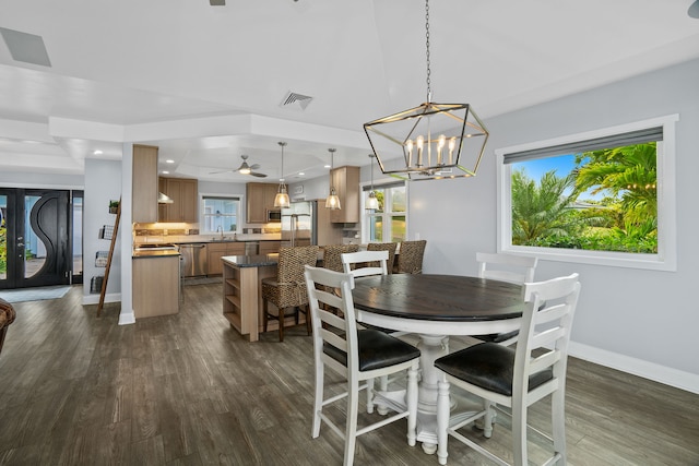 dining area with dark wood-type flooring and ceiling fan with notable chandelier