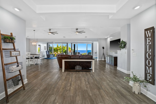 living room with dark hardwood / wood-style flooring and ceiling fan with notable chandelier