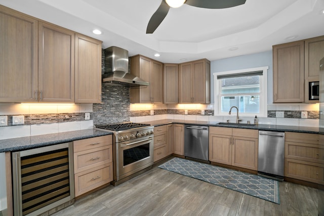 kitchen featuring sink, wall chimney exhaust hood, stainless steel appliances, beverage cooler, and light hardwood / wood-style flooring