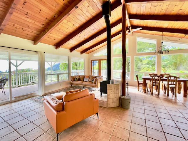 sunroom featuring lofted ceiling with beams, wooden ceiling, and a chandelier