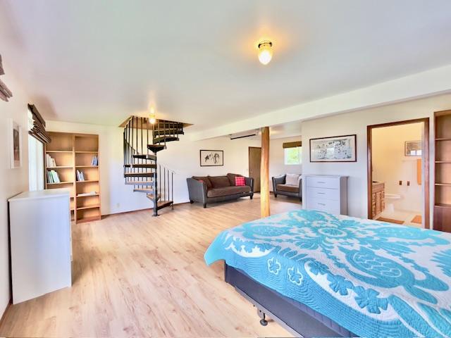 bedroom featuring hardwood / wood-style floors and ensuite bath