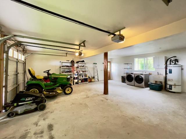 garage featuring sink, gas water heater, a garage door opener, and washing machine and clothes dryer