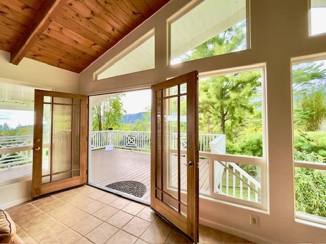 doorway to outside with french doors, lofted ceiling with beams, and plenty of natural light