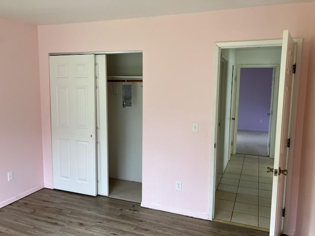 unfurnished bedroom with a closet and dark wood-type flooring