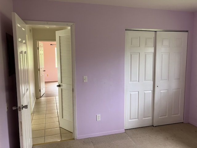 unfurnished bedroom featuring a closet and light tile patterned floors