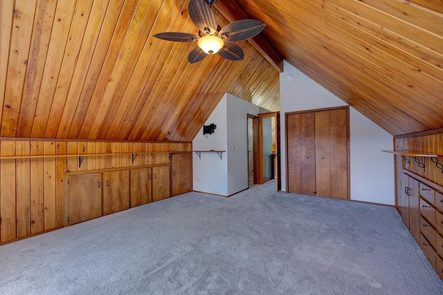 bonus room with light carpet, wood walls, ceiling fan, and vaulted ceiling