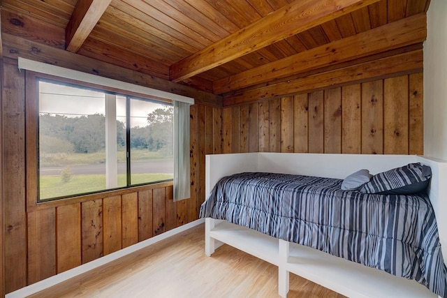 bedroom with beamed ceiling, hardwood / wood-style flooring, wooden walls, and wooden ceiling