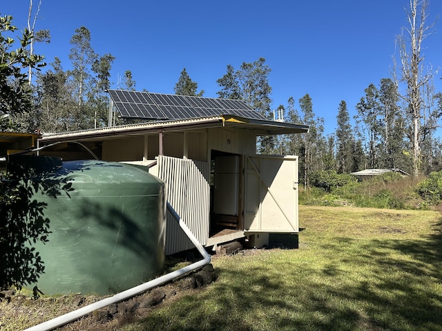 view of side of property with a lawn and solar panels