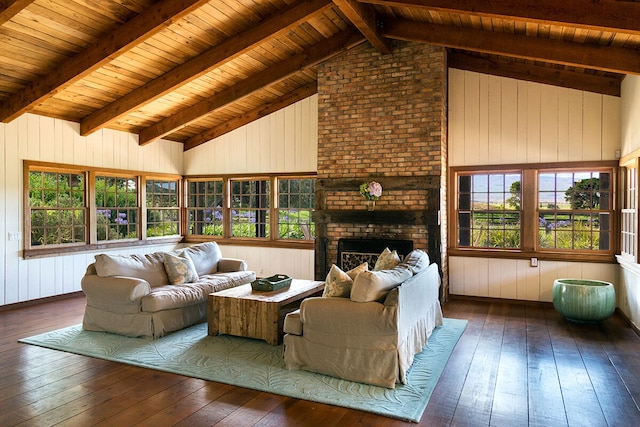 living room with hardwood / wood-style flooring, vaulted ceiling with beams, a healthy amount of sunlight, and a brick fireplace