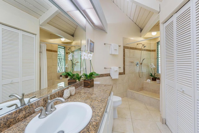 bathroom featuring tile patterned floors, vanity, tiled shower, and toilet