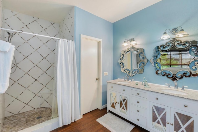 bathroom with hardwood / wood-style flooring, vanity, and walk in shower