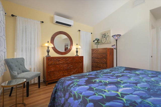 bedroom featuring vaulted ceiling, wood-type flooring, and a wall mounted AC