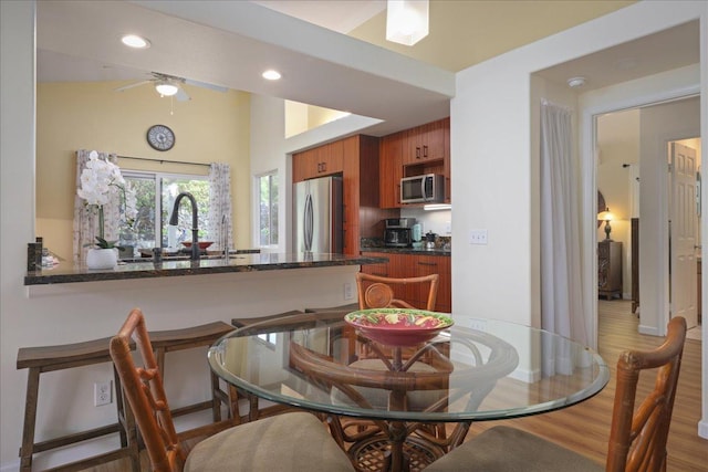 dining room with hardwood / wood-style floors, ceiling fan, and sink