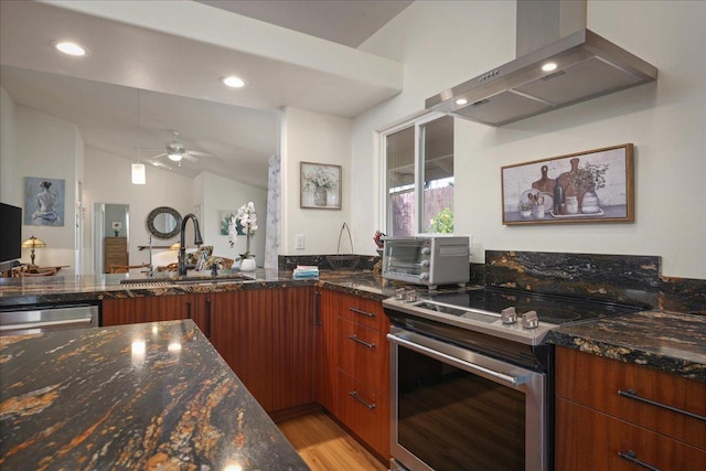 kitchen with ceiling fan, stainless steel appliances, dark stone countertops, lofted ceiling, and exhaust hood