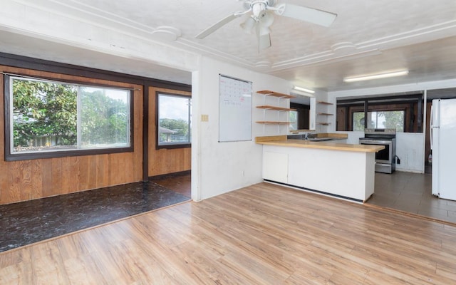 kitchen featuring kitchen peninsula, electric stove, wood walls, butcher block countertops, and white refrigerator