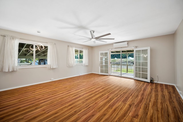 spare room with wood-type flooring, french doors, an AC wall unit, and ceiling fan