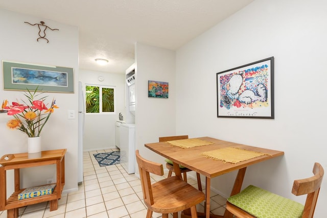 tiled dining room with stacked washer and dryer