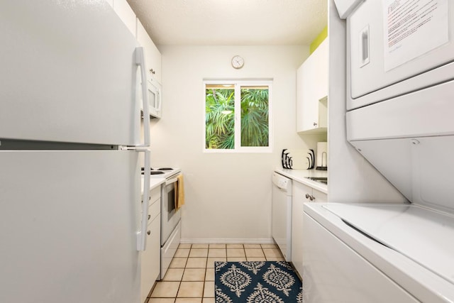 clothes washing area featuring light tile patterned floors and stacked washer and dryer