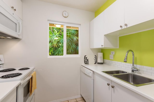 kitchen with tasteful backsplash, white appliances, sink, white cabinetry, and light tile patterned flooring