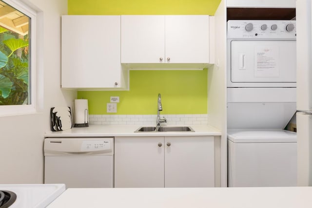 laundry area with sink and stacked washing maching and dryer