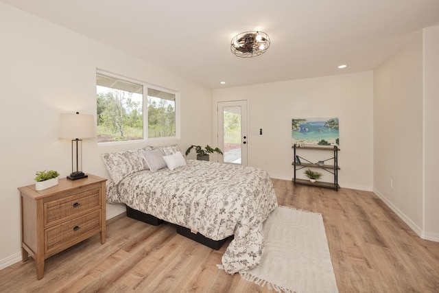 bedroom with access to exterior and light hardwood / wood-style flooring