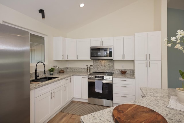 kitchen featuring light stone countertops, sink, white cabinets, and appliances with stainless steel finishes