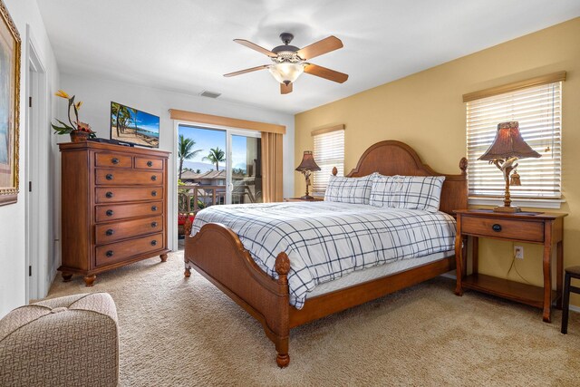 bedroom with access to outside, multiple windows, ceiling fan, and light colored carpet