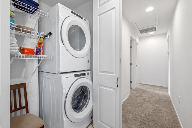 laundry area featuring light colored carpet and stacked washer and clothes dryer