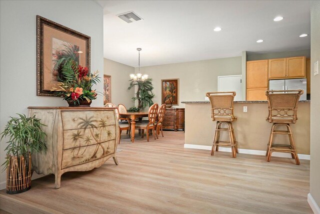 dining area featuring a chandelier and light wood-type flooring