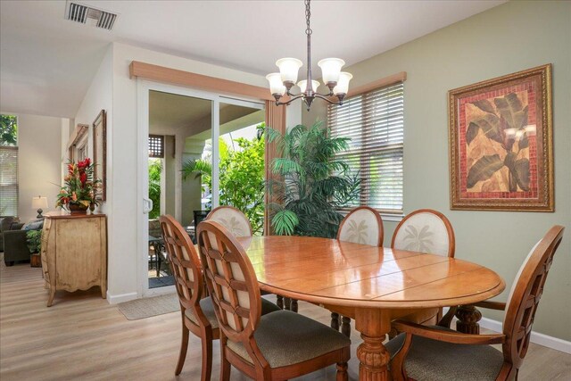 dining room with light hardwood / wood-style floors, a wealth of natural light, and a chandelier