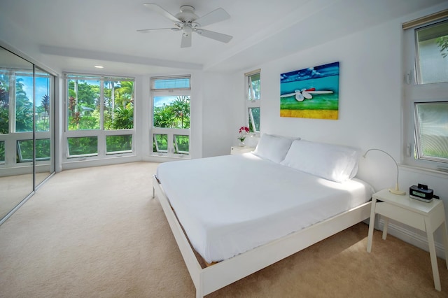 bedroom featuring ceiling fan, light carpet, and a closet