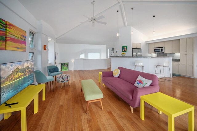 living room with beamed ceiling, light hardwood / wood-style floors, high vaulted ceiling, and ceiling fan