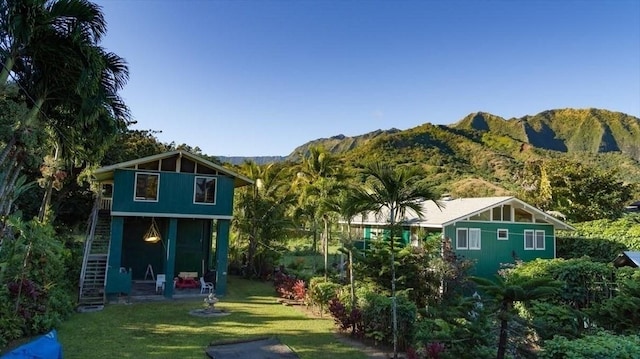 rear view of property featuring a lawn and a mountain view